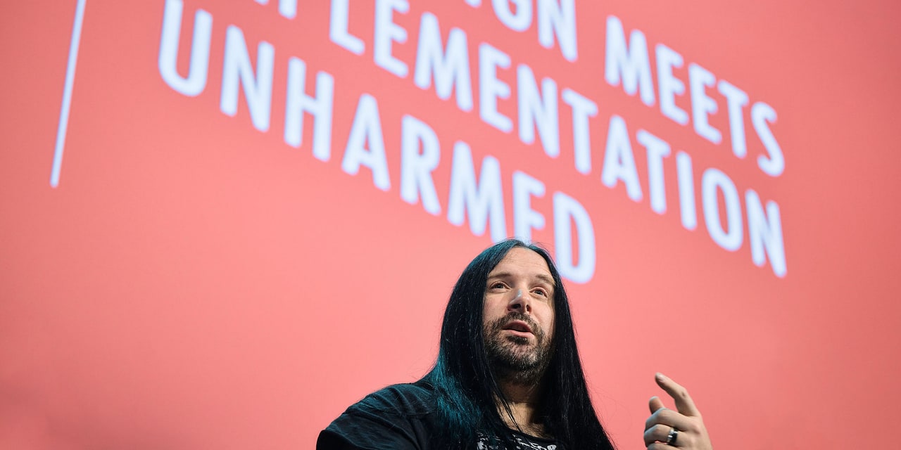 David Whitney on stage at NDC Oslo 2025, in front of a slide with the text ‘no design meets implementation unharmed’