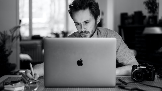 Man looks serious while using laptop